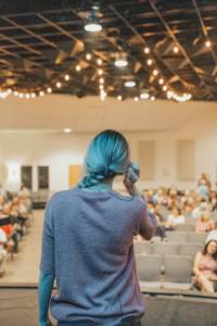 Woman touching hair on stage in front of crowd